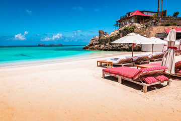 Luxury beach chairs and umbrella on exotic beach in St Barths, Caribbean Island.