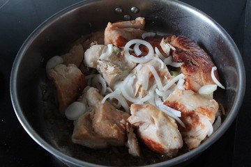  roasted chicken in a frying pan with onion 