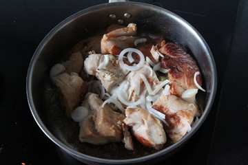  roasted chicken in a frying pan with onion 