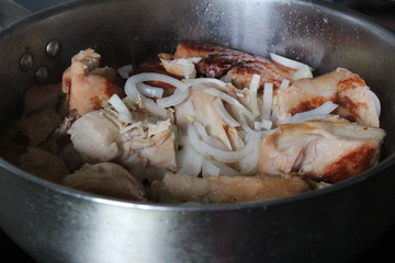  roasted chicken in a frying pan with onion 