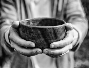 Men hand holding empty wooden bowl.