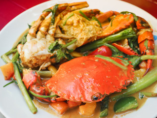 Fried crab with curry powder on white dish. Popular Thai seafood.