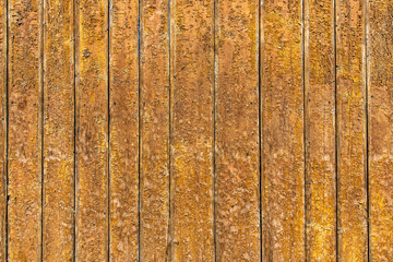 Old wooden wall with relief texture, shabby, dirty, and cracked paint. Retro background in brown color