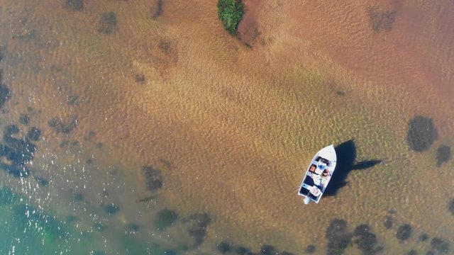 Drone shot of fisherman fly casting for trout from a boat in a lake
