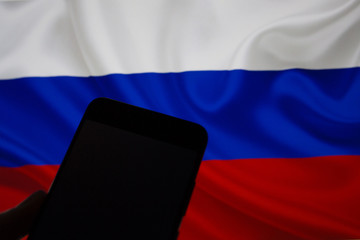 Smartphone in hand without internet connection on the background of the Russian flag