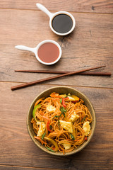 Egg Schezwan/hakka noodles, popular indochinese food served in a bowl with chopsticks. selective focus