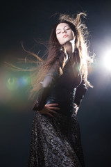 Young attractive woman with long hair like a witch. Femme brunette, mystical fantasy style