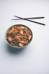 Chicken Hakka/Schezwan noodles served in a bowl with chopsticks. selective focus