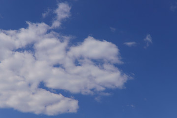 Obraz premium Blue sky background with white clouds on a sunny day. Nature concept. Horizontal, plenty of space for text.