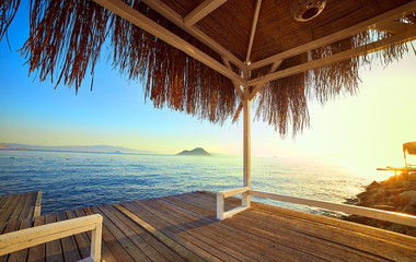 Bungalow on the sea at sunset. Wooden pavilions on the shore of a sandy beach - Bodrum, Turkey