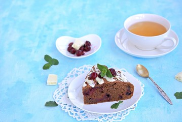 Dessert, homemade chocolate cake with cherries on a white plate. Decorated with white chocolate and cherry. Selective focus