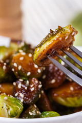 Roasted Brussels sprouts in a white bowl on a wooden background