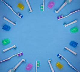 multicolored toothbrushes on a blue background with copy space. Flet lay. Top view. © Olga