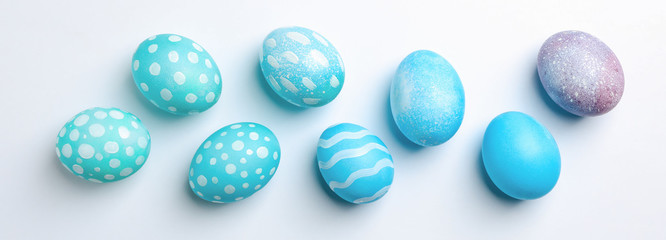 Flat lay composition with Easter eggs on white background, space for text