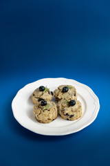 Fresh Baked Raspberry and Blueberry oatmeal wheat Scones set on Blue Background.