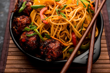 Manchurian Hakka / Schezwan noodles, popular indochinese food served in a bowl. selective focus
