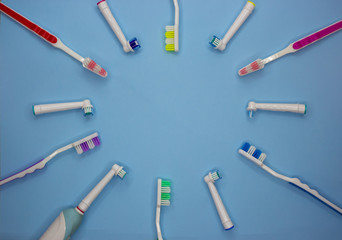 multicolored toothbrushes on a blue background with copy space. Flet lay. Top view. © Olga