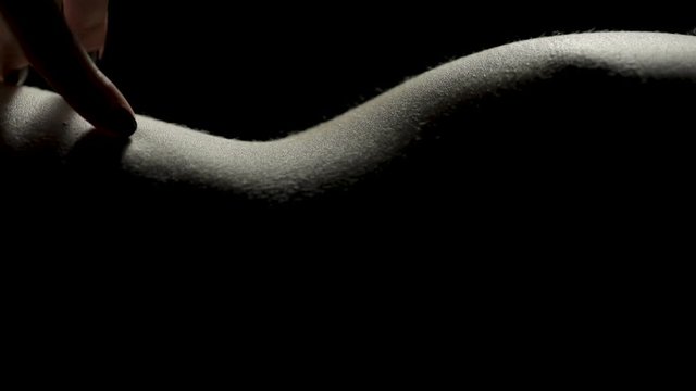Close-up of sensual fingers as they drag across bare skin with copyspace on the bottom