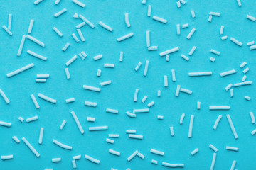 top view of blue sprinkles over blue background, decoration for cake and bakery