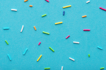 flat lay of colorful sprinkles over blue background, festive decoration for Valentines day,...