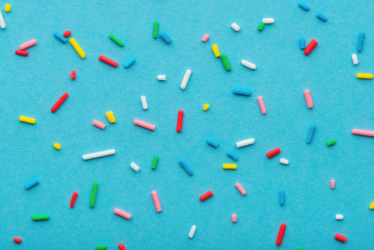 top down of colorful sprinkles over blue background, festive decoration for holiday and party time