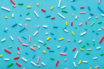 Foto op Plexiglas colorful sprinkles over blue background, decoration for cake and bakery © Alisa