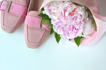 Suede leather ballerina flats shoes wrapped in gift tissue paper  with pink peonies bouquet and copy space