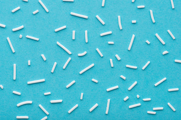 top view of white sprinkles over blue background, decoration for cake and bakery