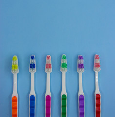 A lot of toothbrushes lie on a pastel blue background with copy space. Top view, flat lay. Minimal concept