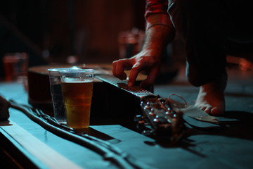 Guitarist plucking an acoustic guitar laid on a stage