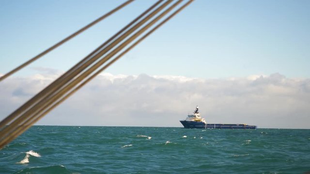 Blue offshore supply vessel seen from another boat at sea. Off the coast of Peterhead, Scotland