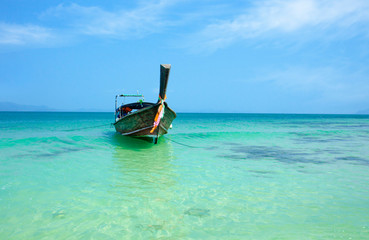Fototapeta na wymiar Seascape with transparent azure water and traditional thai boat. Azure lagoon in Thailand. Andaman Sea.