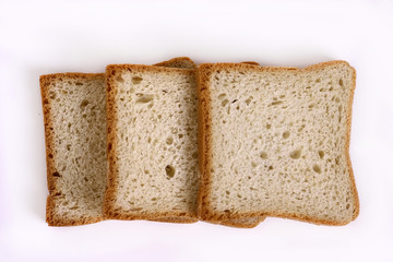 Three slices of white bread on a light table.