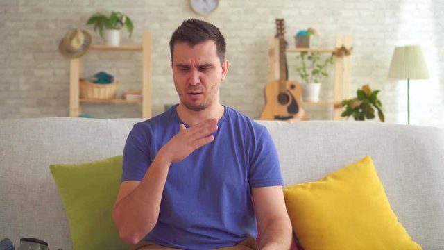 Young man in a modern apartment feels a bad smell and puts on a respirator