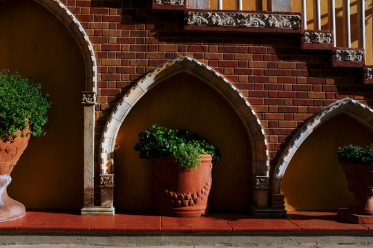 Red Sidewalk With Large Flower Pots And A Stairwell