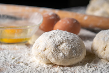 White flour with eggs, butter and dough on a cooking board