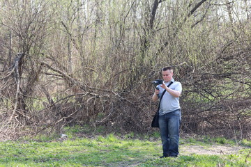 A young man videotaping on a smartphone. Uses gimbal to get smooth shots. Controls the recording by touching the screen.