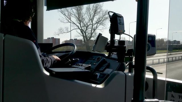 Female bus driver driving along the road