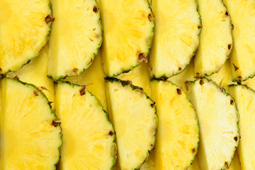 Pineapple juicy yellow slices background. Top view.