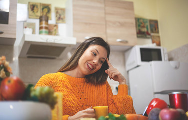 Healthy young woman in a kitchen with fruits and vegetables and juice .