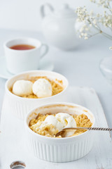 Apple crumble, a spoon with ice cream, streusel. Side view, vertical. Morning breakfast.