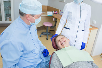 Obraz premium Elderly woman sits in a dental chair as a patient. People health care, dentistry, medicine concept. Doctor and patient. Teeth dentist with patient in hospital Description