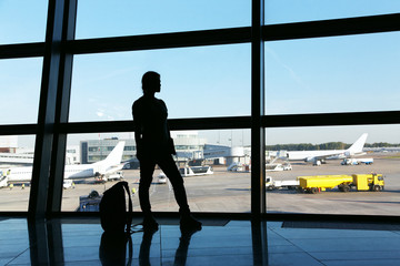 Fototapeta na wymiar silhouette of a woman traveler with backpack in airport