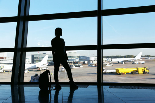 silhouette of a woman traveler with backpack in airport