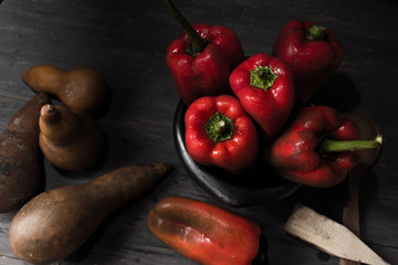 STILL LIFE OF RED PEPPERS ON A RUSTIC WOODEN TABLE