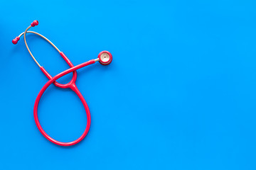 diagnostic and cure of cardiac disease with stethoscope on blue background top view mock-up
