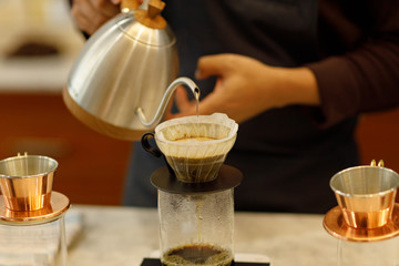 Young man barista pouring coffee.