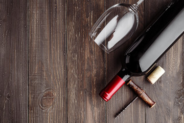 Glass bottle of wine with corks on wooden table background.Top view with copy space