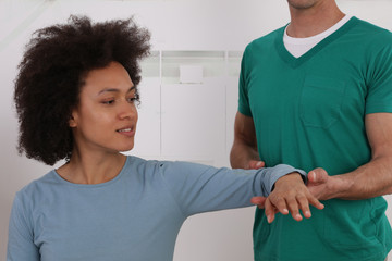 Fototapeta premium Woman having chiropractic back adjustment in rehabilitation clinic. Osteopathy, Physiotherapy concept