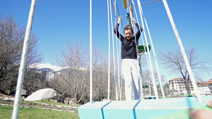 Teen girl in adventure park. Adventure park is place which can contain wide variety of elements, such as rope climbing exercises, obstacle courses and zip-lines. They intended for recreation